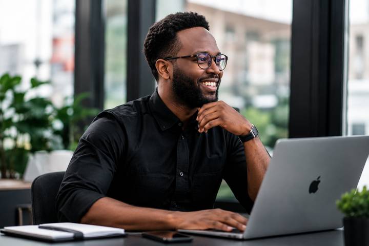 Ralph Desmornes smiling while working at a laptop